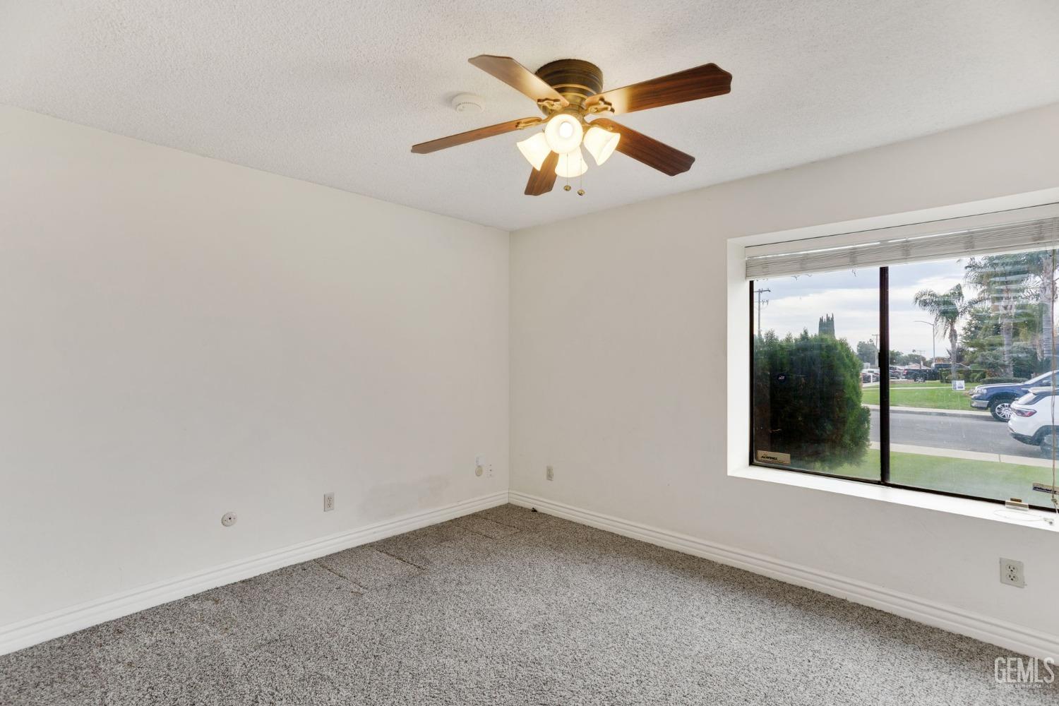 Undisclosed Address Bakersfield, CA 93306 - Photo 38 of 51 an empty room with chandelier fan and windows