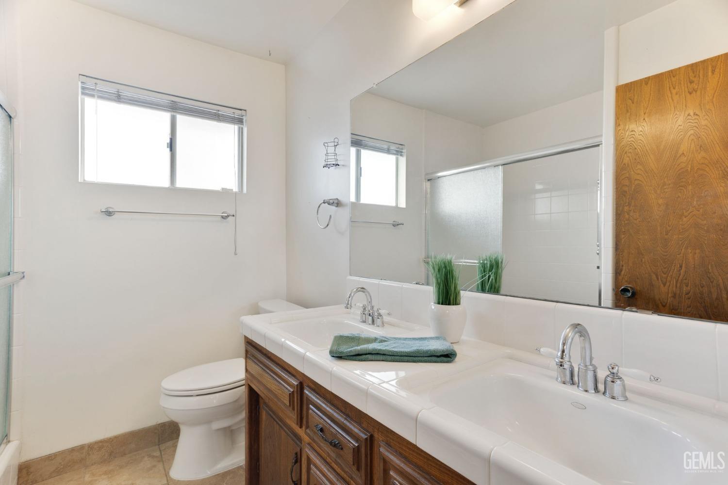 Undisclosed Address Bakersfield, CA 93306 - Photo 40 of 51 a bathroom with a granite countertop sink a toilet and a mirror