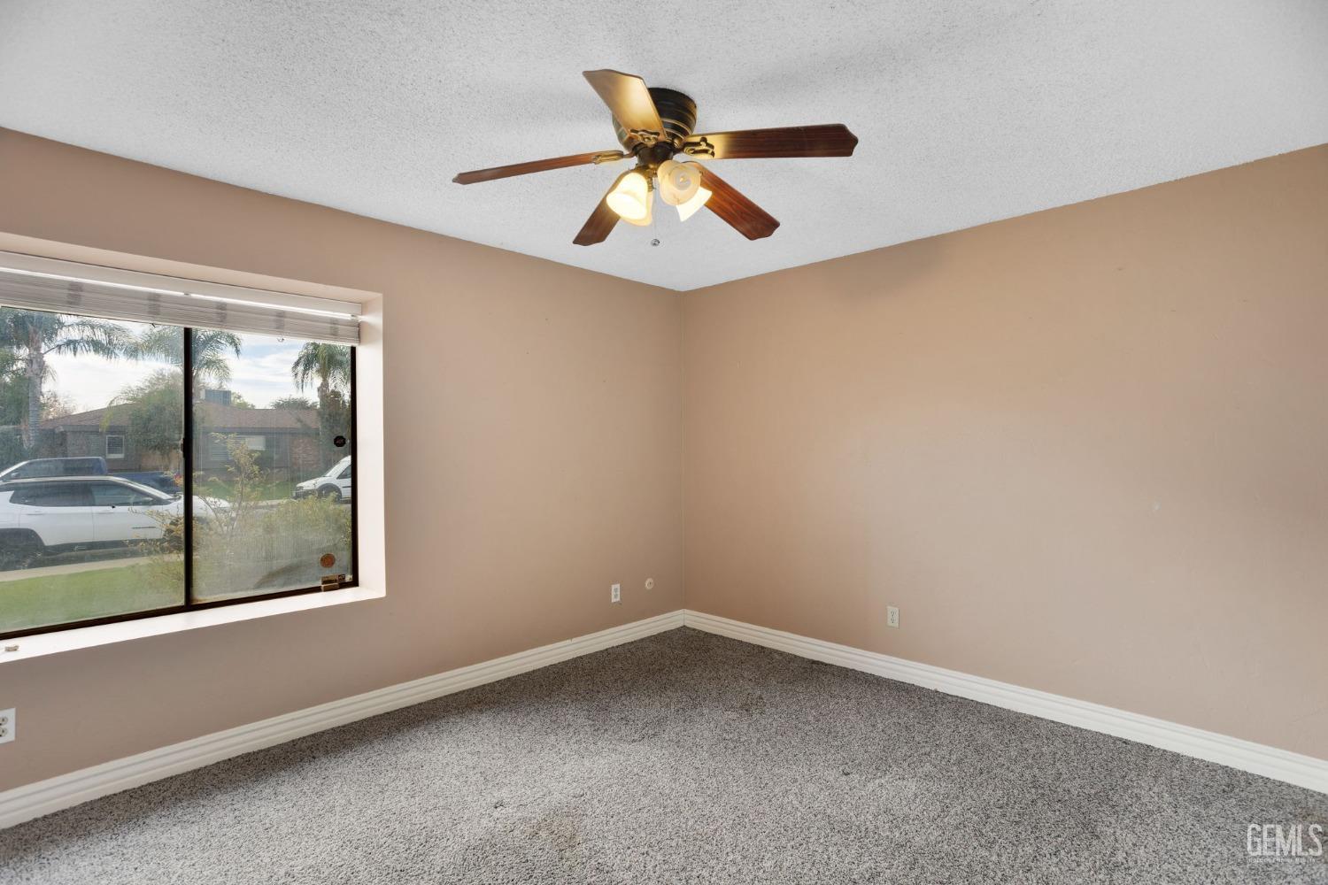 Undisclosed Address Bakersfield, CA 93306 - Photo 41 of 51 an empty room with a window and a ceiling fan