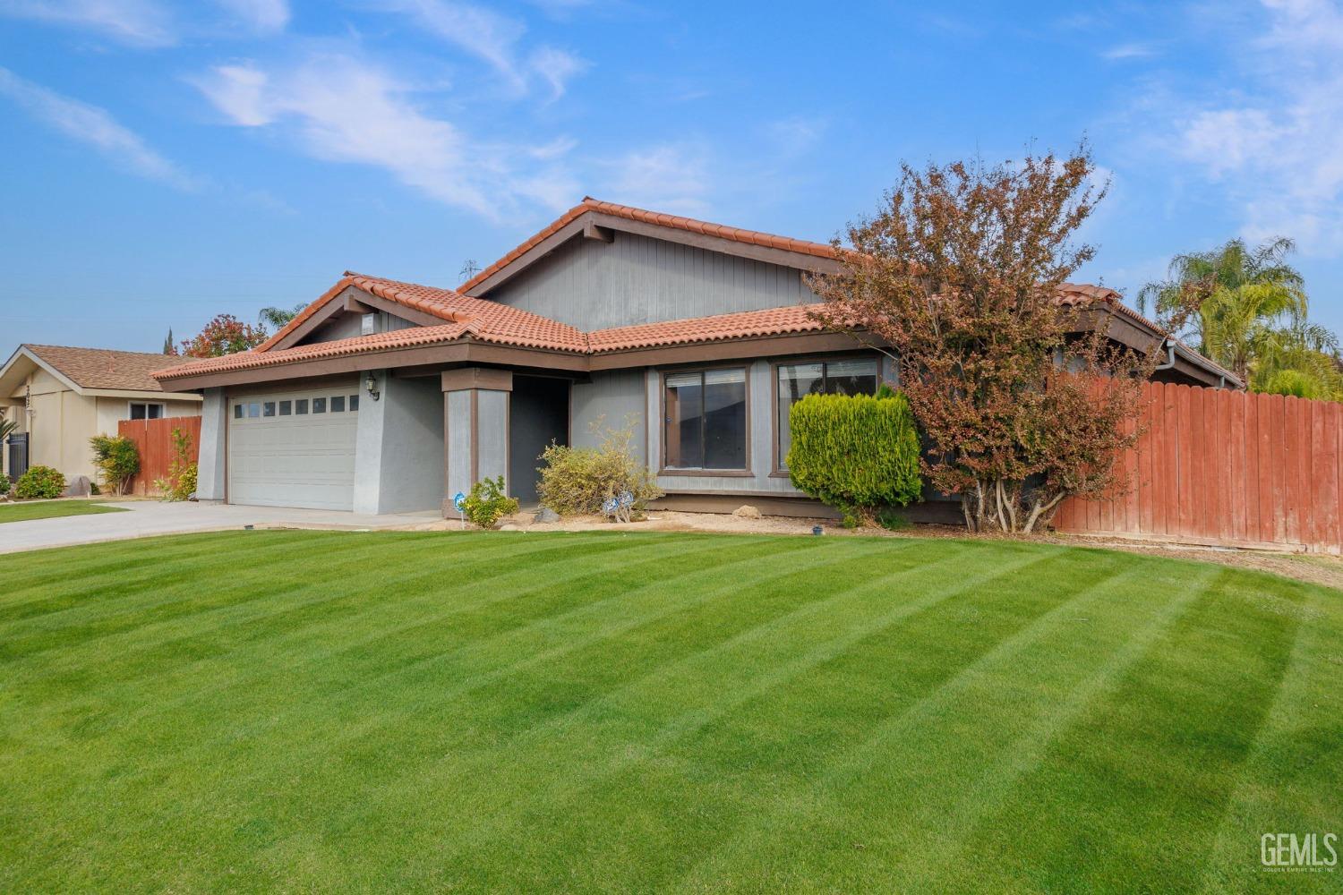Undisclosed Address Bakersfield, CA 93306 - Photo 7 of 51 a front view of a house with a garden