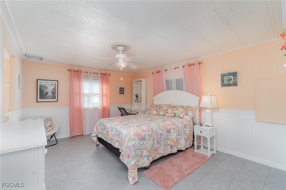 5508 Colonial Road North Fort Myers, FL 33917 - Photo 16 of 31 a bedroom with a bed and a chandelier