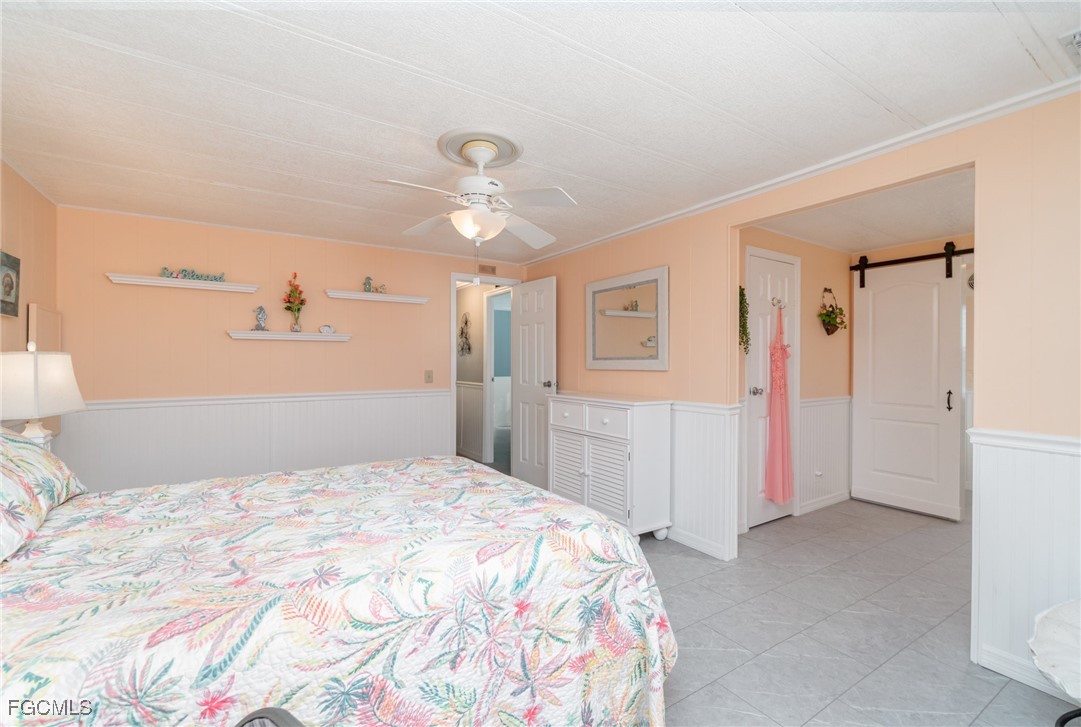 5508 Colonial Road North Fort Myers, FL 33917 - Photo 17 of 31 a bedroom with a large bed and a chandelier