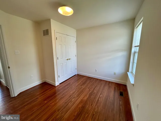 a view of a room with wooden floor and white walls
