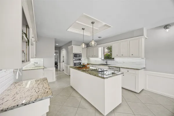 a kitchen with granite countertop white cabinets and sink