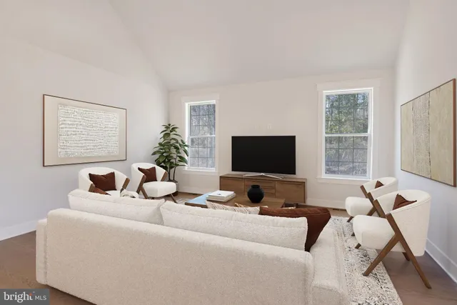 a living room with furniture a flat screen tv and a large window