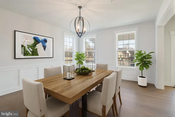 a dining room with furniture potted plants and wooden floor