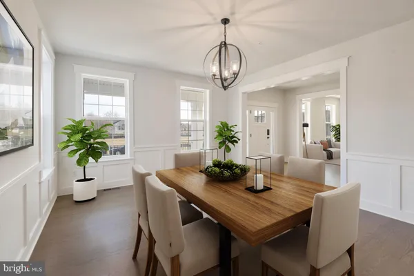 a dining room with furniture potted plants and wooden floor