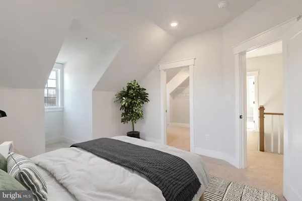 a bedroom with a bed and a potted plant