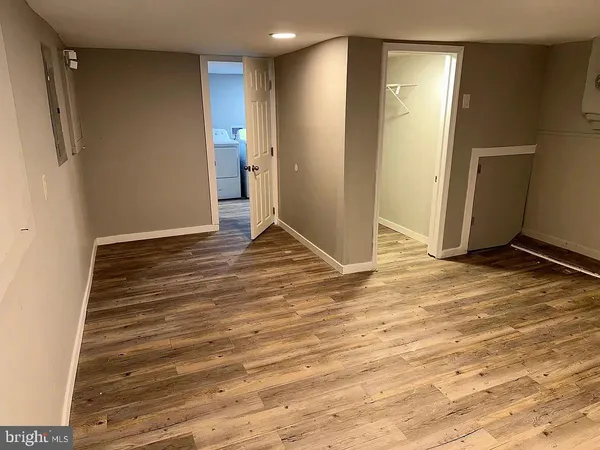 a view of an empty room with closet and wooden floor