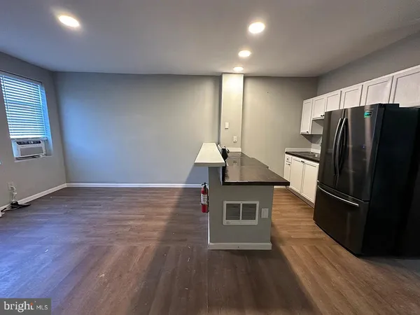 a view of kitchen with a refrigerator cabinets and wooden floor