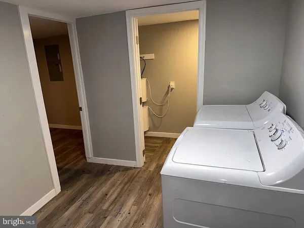 a utility room with wooden floor washer and dryer