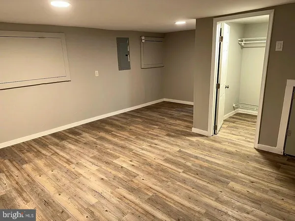 a view of a room with wooden floor and a bathroom