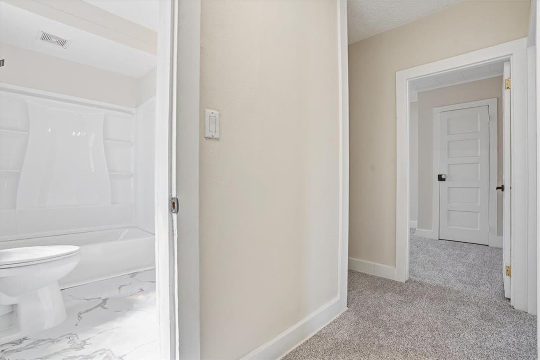 110 Messinger Street Bangor, PA 18013 - Photo 21 of 39 A well-lit corridor offers access to a pristine bathroom and another room beyond.
