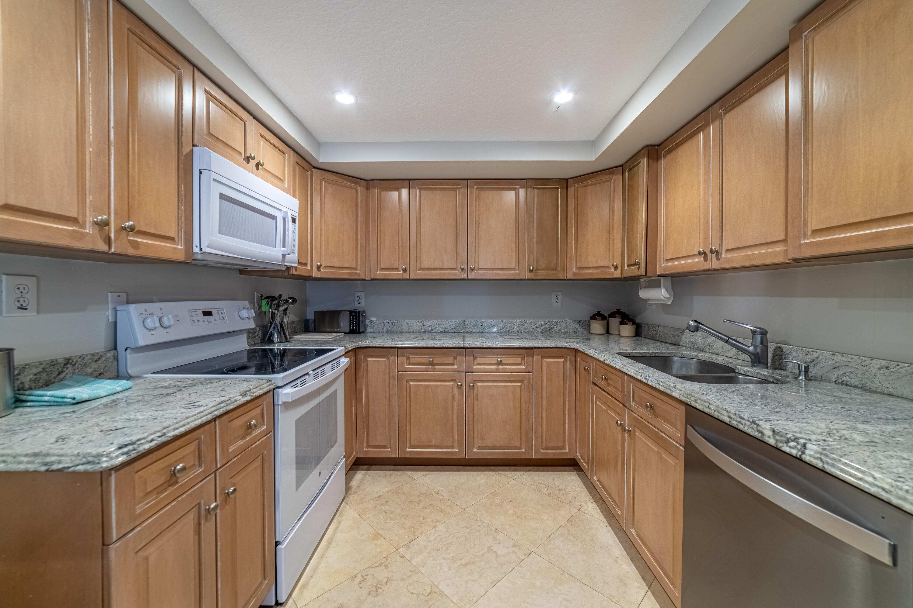 3250 South Ocean Boulevard, Unit 507N Palm Beach, FL 33480 - Photo 30 of 56 a kitchen with granite countertop stainless steel appliances sink stove and cabinets