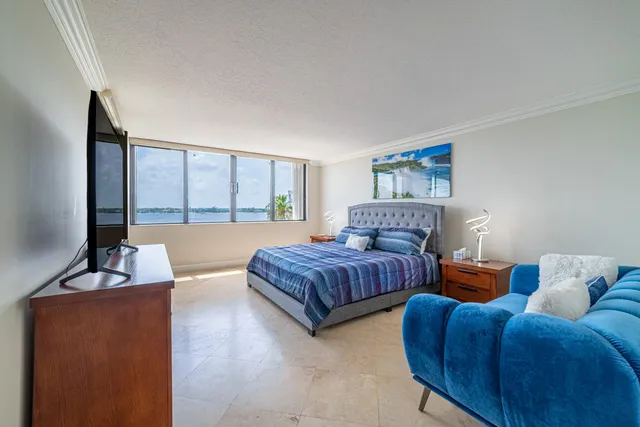 a bedroom with a bed a flat screen tv and a couch