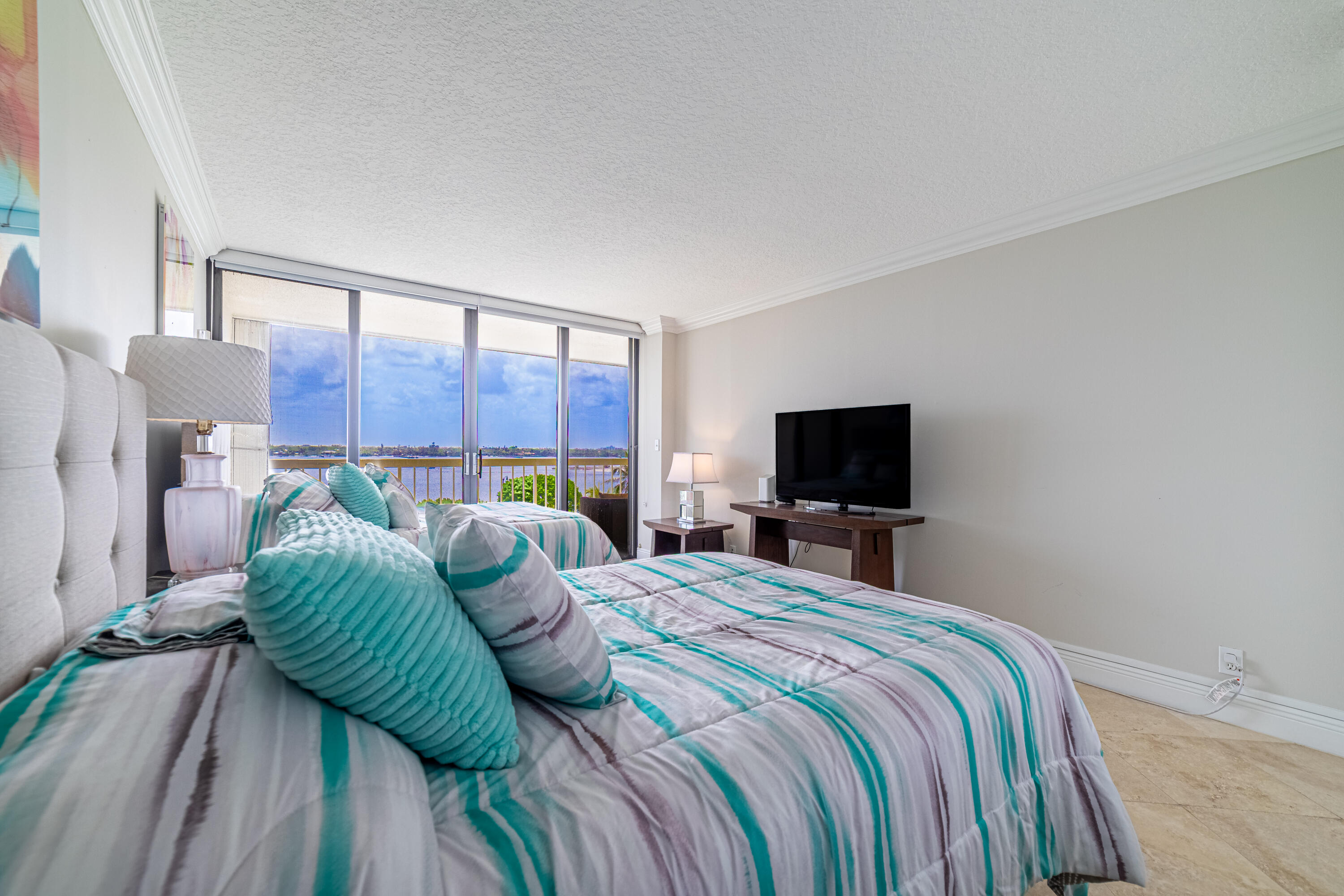 3250 South Ocean Boulevard, Unit 507N Palm Beach, FL 33480 - Photo 40 of 56 a bedroom with a bed a flat screen tv and a couch