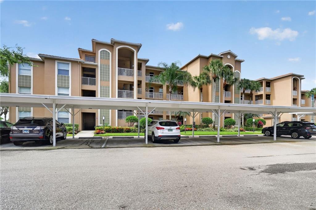 3830 Sawgrass Way, Unit 2922 Naples, FL 34112 - Photo 16 of 43 a car parked in front of a building