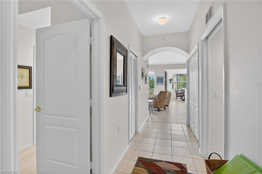 3830 Sawgrass Way, Unit 2922 Naples, FL 34112 - Photo 17 of 43 a hallway with view of living room and dining room
