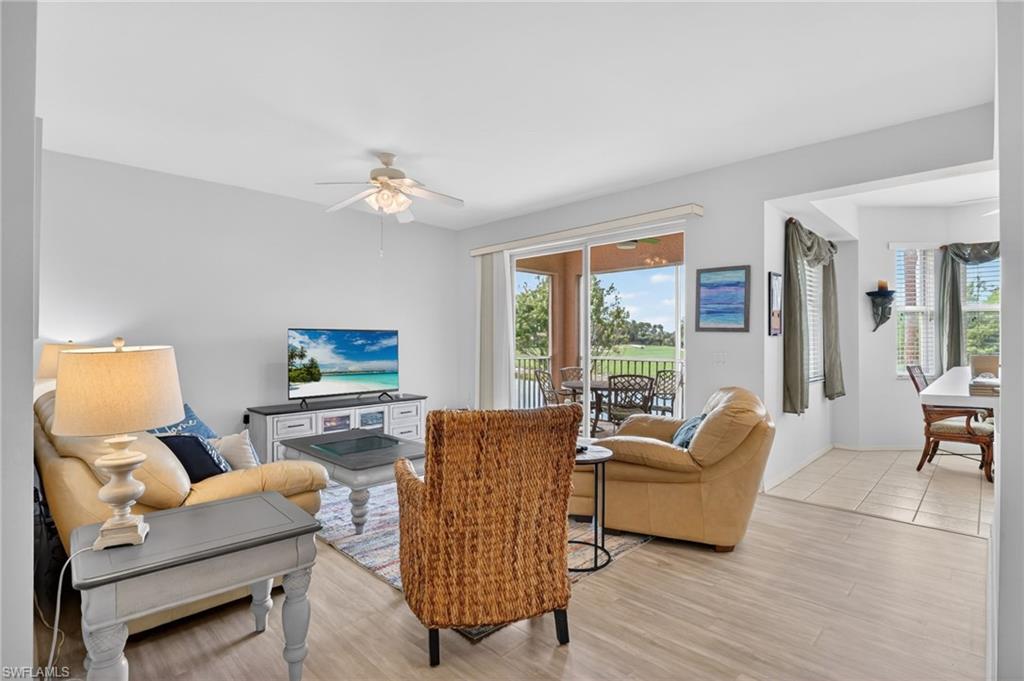 3830 Sawgrass Way, Unit 2922 Naples, FL 34112 - Photo 21 of 43 a living room with furniture a flat screen tv and a large window