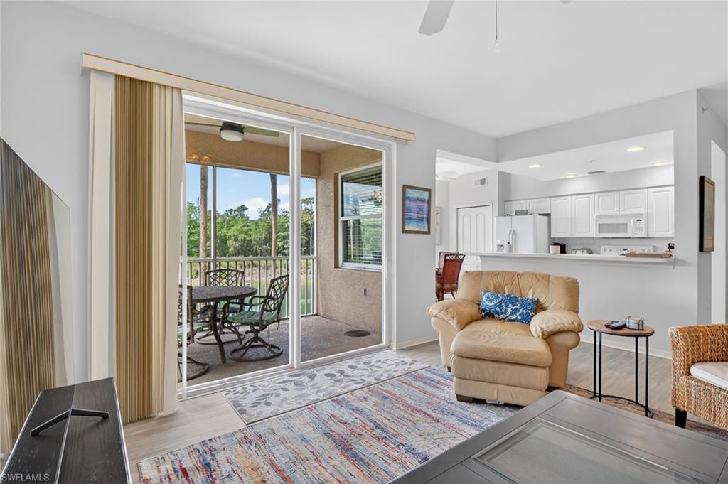 3830 Sawgrass Way, Unit 2922 Naples, FL 34112 - Photo 24 of 43 a living room with furniture and a floor to ceiling window