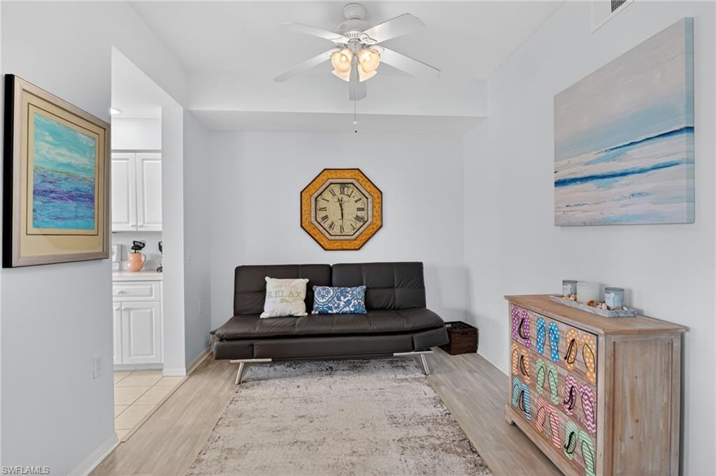 3830 Sawgrass Way, Unit 2922 Naples, FL 34112 - Photo 25 of 43 a living room with furniture and a wall painting