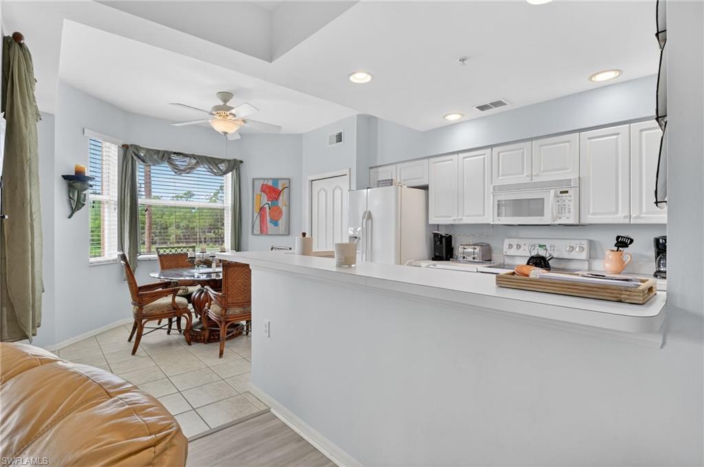 3830 Sawgrass Way, Unit 2922 Naples, FL 34112 - Photo 27 of 43 a living room with stainless steel appliances furniture a flat screen tv and a window