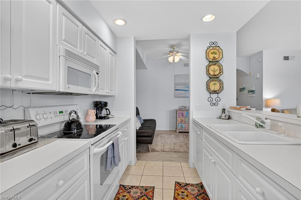 3830 Sawgrass Way, Unit 2922 Naples, FL 34112 - Photo 29 of 43 a kitchen with a sink and cabinets