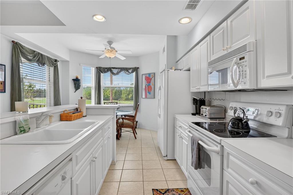 3830 Sawgrass Way, Unit 2922 Naples, FL 34112 - Photo 31 of 43 a kitchen with stainless steel appliances a stove a sink a refrigerator and cabinets