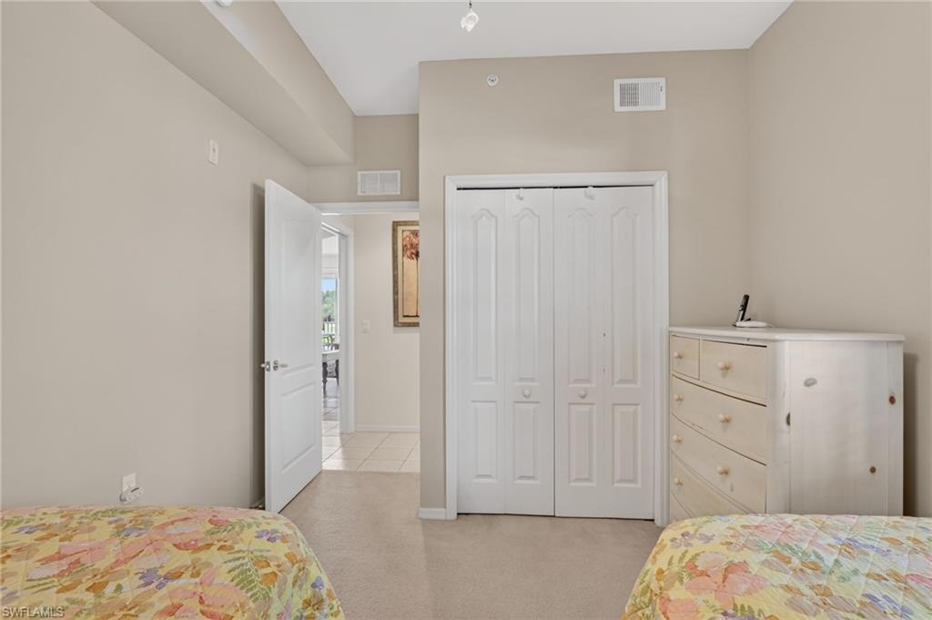 3830 Sawgrass Way, Unit 2922 Naples, FL 34112 - Photo 39 of 43 a bedroom with a bed and hallway