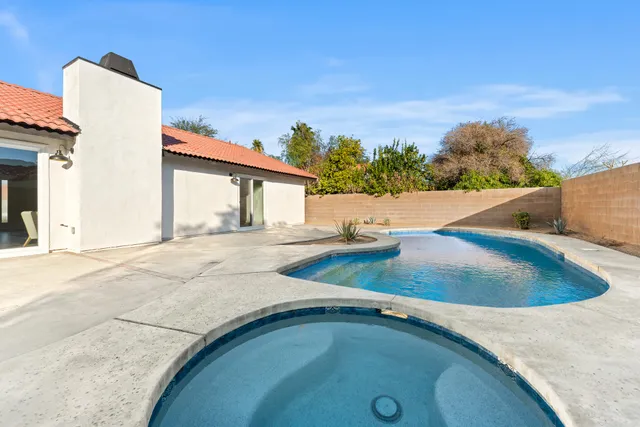a front view of a house with swimming pool having outdoor seating