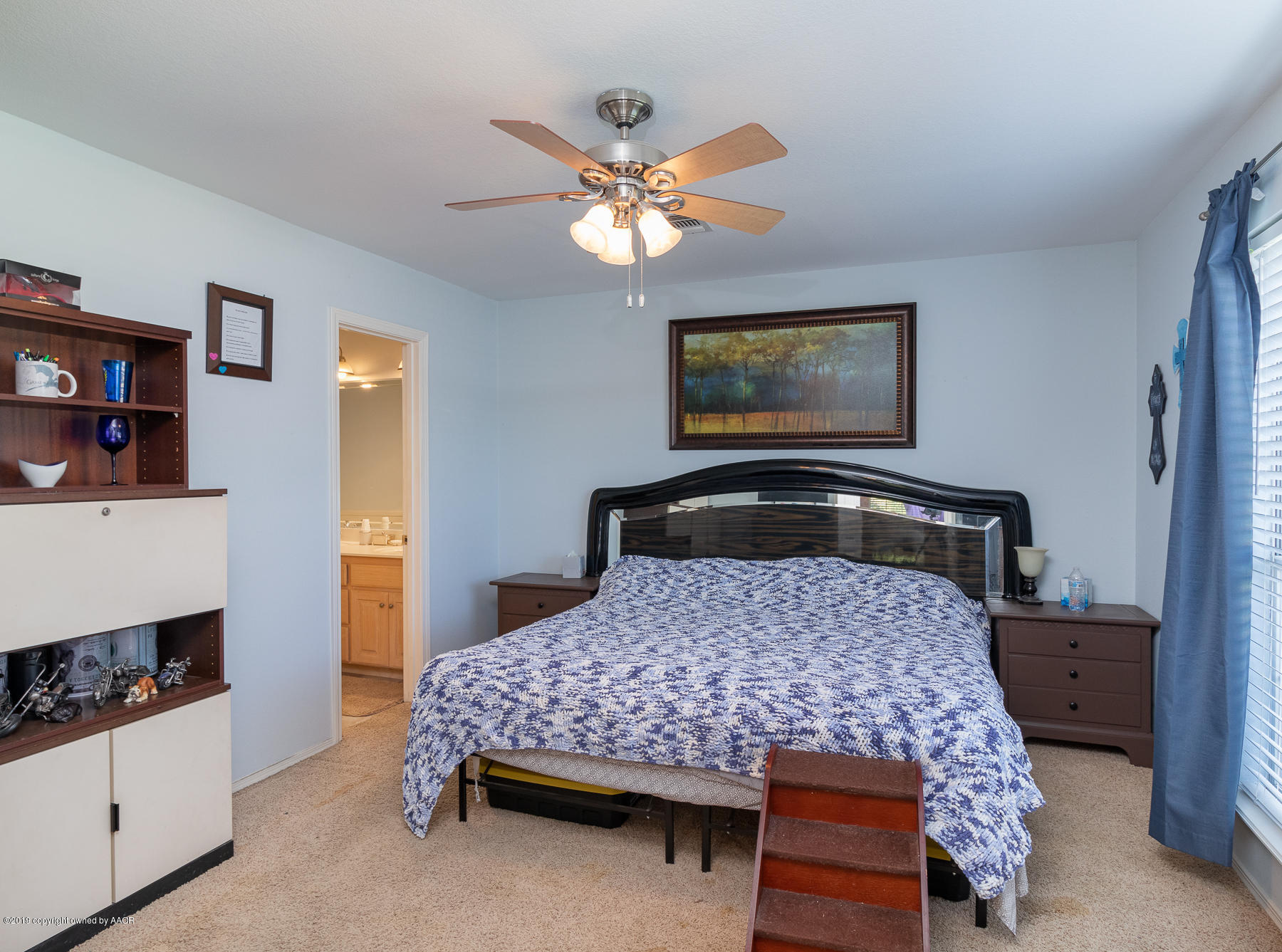 6403 Rally Road Amarillo, TX 79119 - Photo 13 of 24 a bedroom with a bed and a chandelier