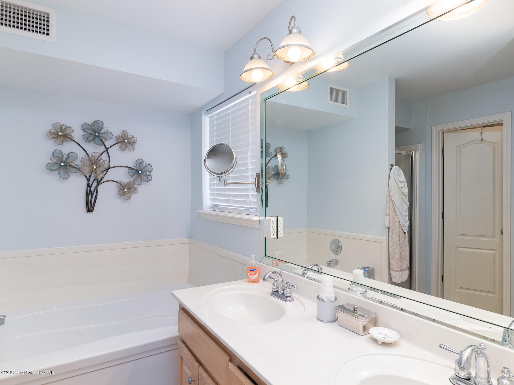 6403 Rally Road Amarillo, TX 79119 - Photo 15 of 24 a bathroom with a sink a large mirror and a bathtub