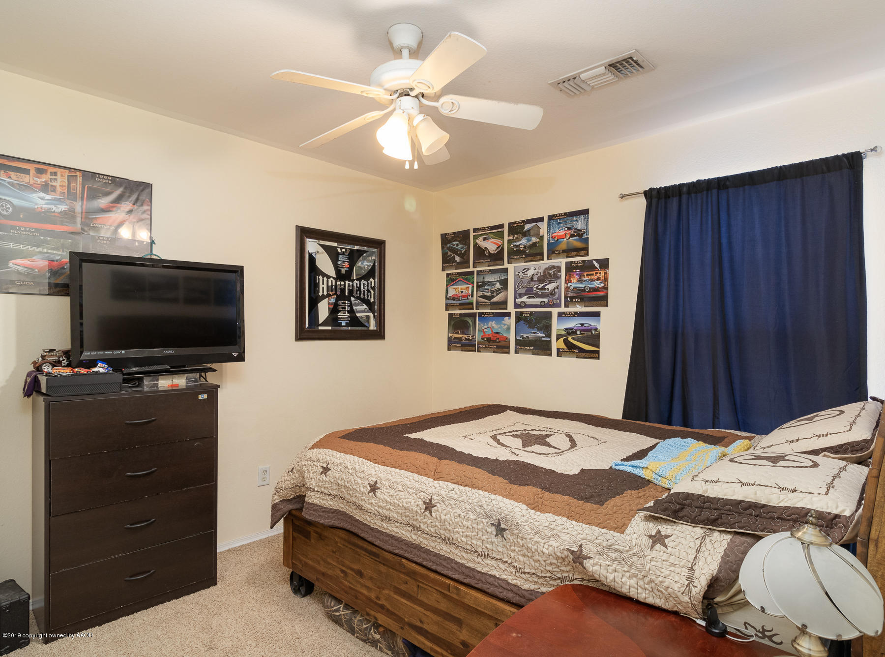 6403 Rally Road Amarillo, TX 79119 - Photo 17 of 24 a bedroom with a bed and a flat screen tv