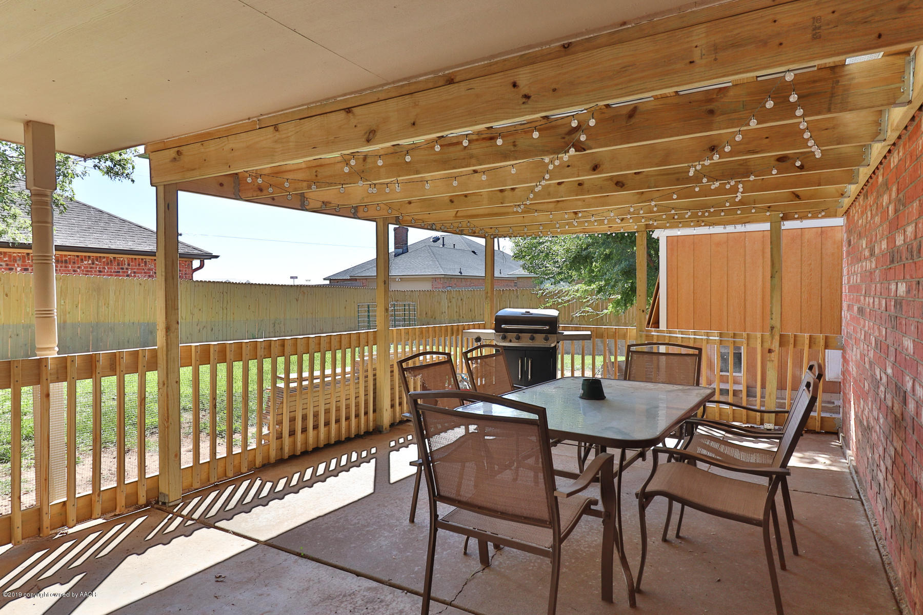 6403 Rally Road Amarillo, TX 79119 - Photo 22 of 24 a view of a patio with a table and chairs and floor to ceiling window with wooden floor