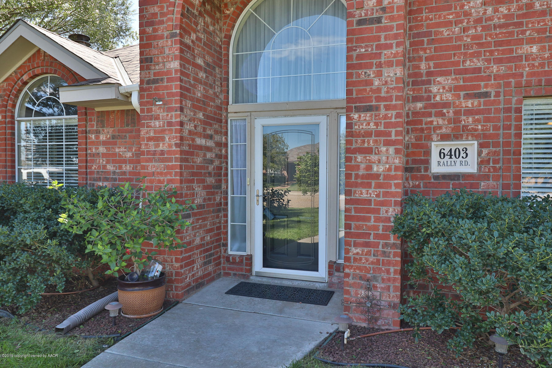 6403 Rally Road Amarillo, TX 79119 - Photo 4 of 24 a view of a brick house with potted plants