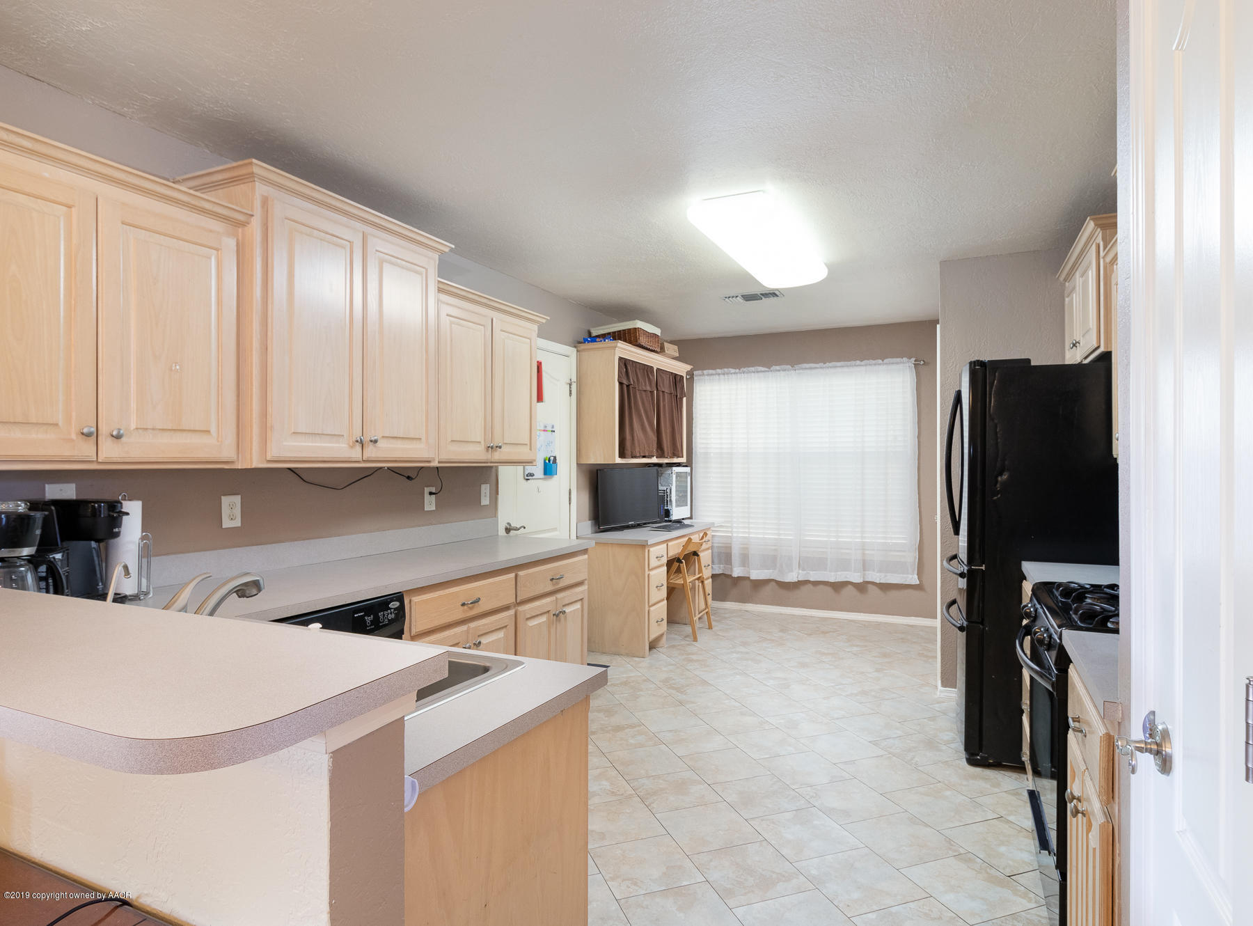 6403 Rally Road Amarillo, TX 79119 - Photo 9 of 24 a kitchen with a refrigerator sink and cabinets