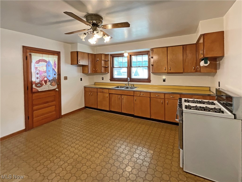 63 Mc Coll Road Colliers, WV 26035 - Photo 3 of 17 Kitchen with light tile patterned flooring, sink, ceiling fan, and white range with gas stovetop