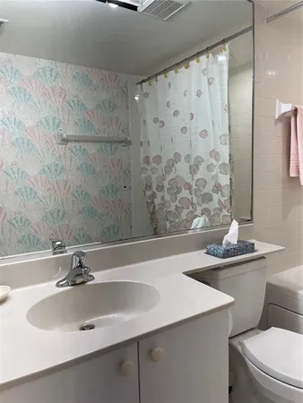 a bathroom with a sink and mirror with toilet
