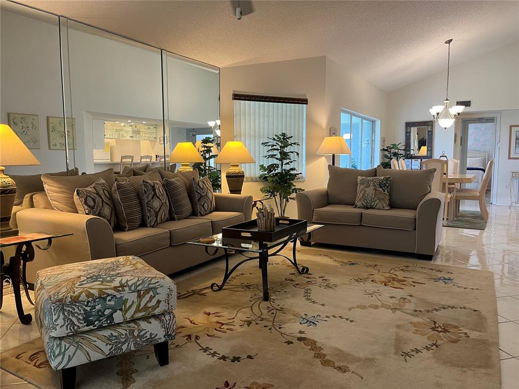 1397 Perico Point Circle, Unit 1397 Bradenton, FL 34209 - Photo 2 of 39 a living room with furniture and a chandelier