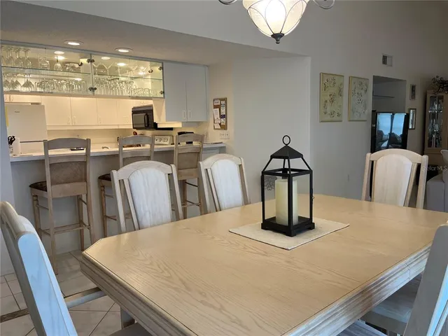 a kitchen with stainless steel appliances granite countertop a table chairs and a refrigerator