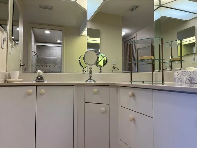 a en suite bathroom with a granite countertop sink and a mirror