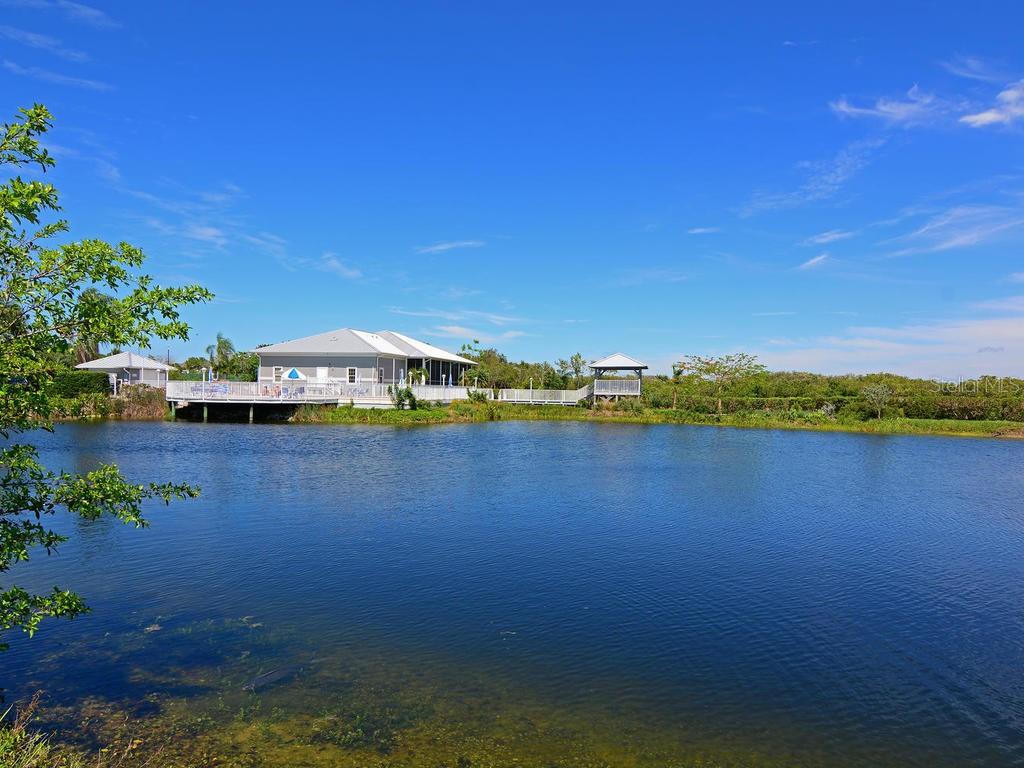 1397 Perico Point Circle, Unit 1397 Bradenton, FL 34209 - Photo 35 of 39 a view of a lake with houses in the background