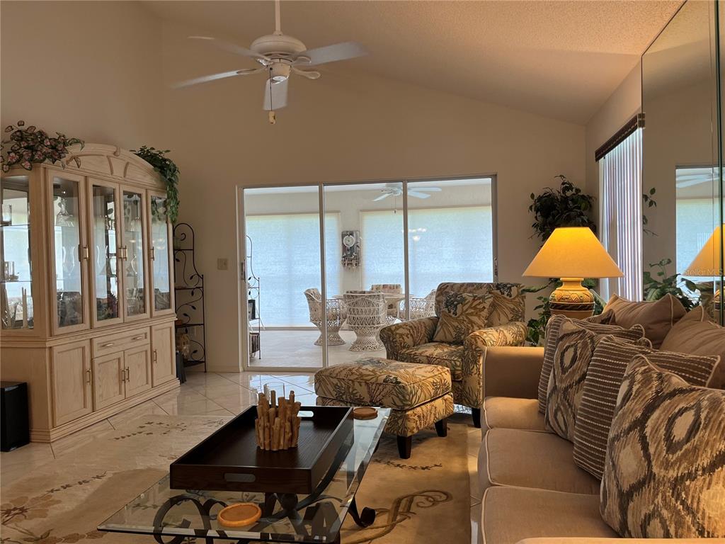 1397 Perico Point Circle, Unit 1397 Bradenton, FL 34209 - Photo 4 of 39 a living room with furniture gym equipment and a chandelier