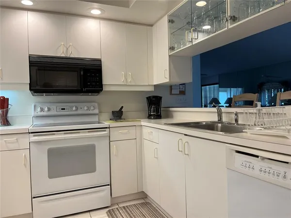 a kitchen with granite countertop a sink stainless steel appliances and cabinets