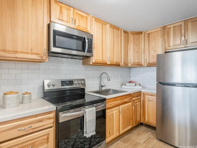 a kitchen with stainless steel appliances granite countertop a refrigerator stove top oven a sink and dishwasher