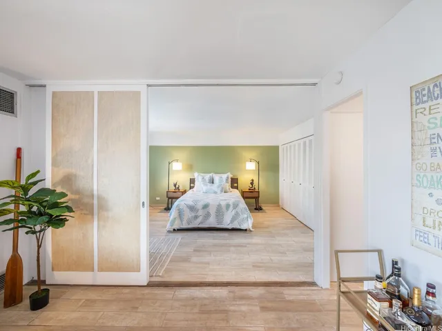 a bedroom with a bed and a potted plant