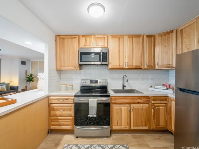 a kitchen with stainless steel appliances granite countertop a stove a sink a microwave a refrigerator and cabinets