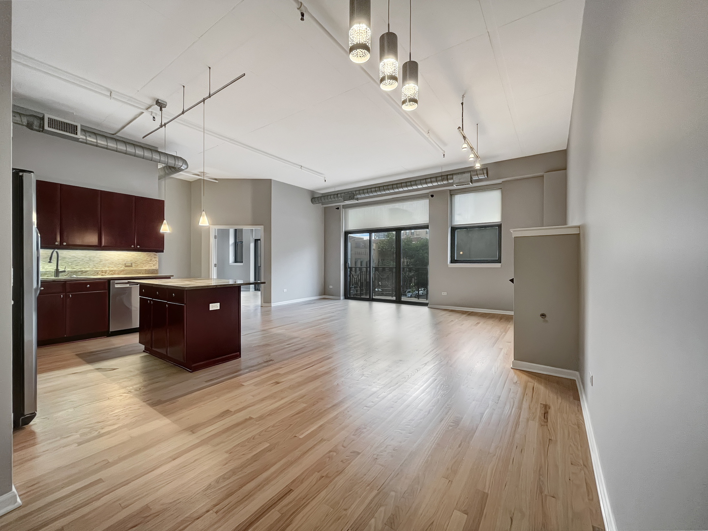 1301 West Madison Street, Unit 201 Chicago, IL 60607 - Photo 3 of 14 a large room with wooden floor and windows