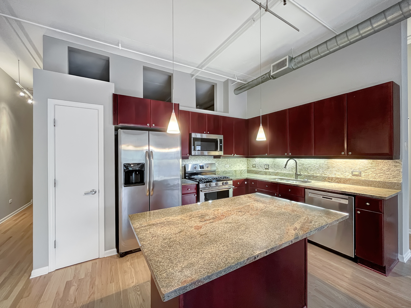 1301 West Madison Street, Unit 201 Chicago, IL 60607 - Photo 4 of 14 a kitchen with stainless steel appliances granite countertop a sink stove and refrigerator