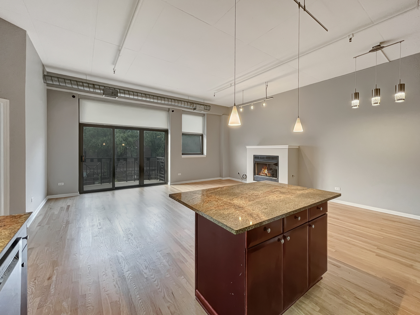 1301 West Madison Street, Unit 201 Chicago, IL 60607 - Photo 7 of 14 a kitchen with a wooden floor and a ceiling fan